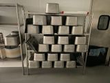 many pans stacked on a metal shelf in a kitchen