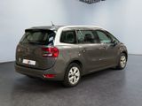 the back of a grey car is parked in a large room
