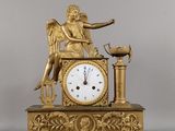 une horloge en or surmontée d'un ange