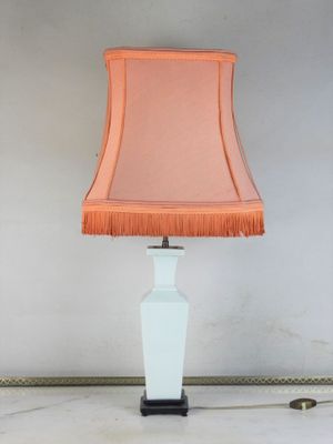 une lampe de table blanche surmontée d'un abat-jour rose
