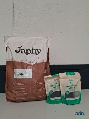 deux sacs de croquettes pour chien et un sac de croquettes pour chien par terre