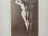 une vieille photo d'une femme nue allongée sur un lit
