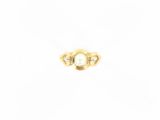 gros plan d'une bague en or contenant une perle