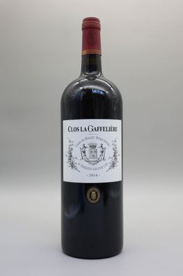 une bouteille de vin rouge posée sur une table blanche
