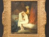 painting of a naked woman sitting on a bed in a gold frame