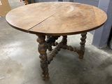 an old table with a wooden top and wooden legs