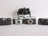 several cameras are lined up on a white surface with a white background