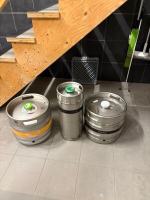 three kegs sitting on the floor next to the stairs