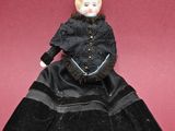 an old doll is sitting on a red surface with a red background