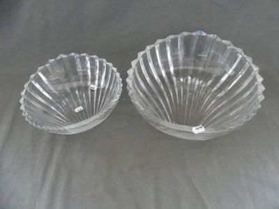 une paire de bols en verre transparent en forme de coquillage posés sur un tissu blanc