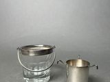 a silver bucket and a glass on a table