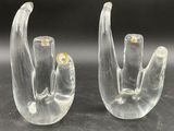 pair of clear glass hand sculptures sitting on a black surface