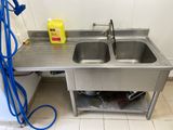 two sinks in the kitchen with a blue hose on the floor