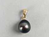 a close up of a black pearl pendant on a white surface