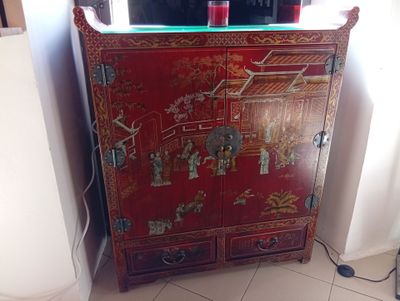 une armoire rouge surmontée d'un miroir