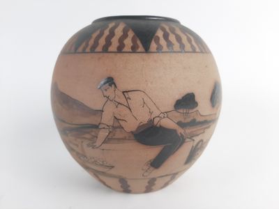 a vase with a picture of a woman sitting on the ground