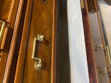 a wooden cabinet with a drawer with a roll of toilet paper in it