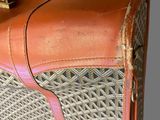 a brown and tan suitcase with a handle on a table