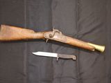 un fusil et un couteau posés sur un tissu noir