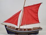 a model of a sailboat with red sails