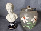 a vase with a bust of a woman next to a vase with flowers painted on it