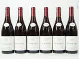 six bouteilles de vin rouge sont alignées sur une surface blanche