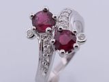 a white gold ring with two ruby stones and diamonds