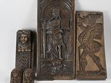 three wooden carvings of a man and a woman and a lion