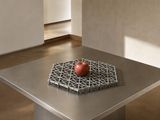 une table en métal sur laquelle est posée une pomme rouge