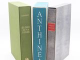 trois livres sont empilés sur une surface blanche