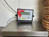 an image of a scale on a counter with a wicker basket in the background