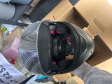 someone is holding a helmet in their hand while standing in front of a cardboard box