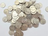 une pile de pièces d'argent sur une surface blanche