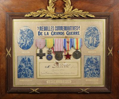 une vieille photo encadrée représentant des médailles, ainsi que des médailles exposées dans un cadre en bois