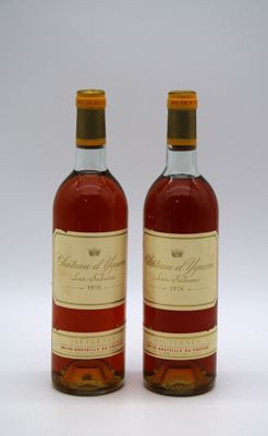 deux bouteilles de vin posées l'une à côté de l'autre sur une surface blanche