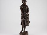 a bronze statue of a man in a dress and hat