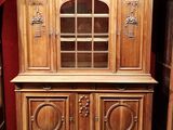 un vaisselier en bois surmonté d'une porte vitrée