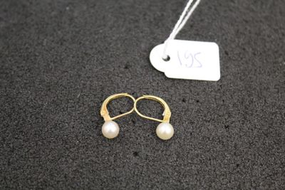 a close up of a pair of earrings and a price tag on a table