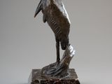 statue of a pelican on a marble base on a gray background