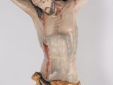 a statue of jesus on a cross with blood on it