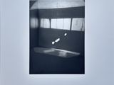 black and white photograph of a person on a skateboard in a room