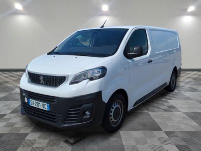 la camionnette blanche est garée dans une grande pièce au sol en damier