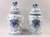 two blue and white vases with a coat of arms on them