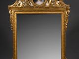 un miroir ancien dans un cadre doré, représentant le portrait d'une femme