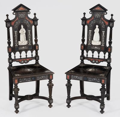 a pair of carved chairs with carvings on the back of them