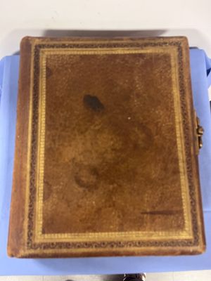 un vieux livre posé sur une table bleue, à côté d'une paire de chaussures