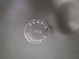 a close up of a silver plate with a stamp on it