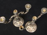 pair of silver candlesticks on a black background