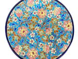 a close up of a blue plate with flowers on it