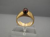 une image représentant une bague en or sertie d'une pierre rouge